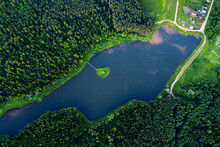 Aerial Top Down View Of The Pond In Coniferous Forest With Little Island In The Middle