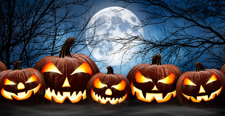 Wall Mural - five spooky halloween pumpkins in a row, jack o lantern, with evil face and eyes on a wooden bench, 