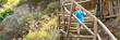 © Ksenia - cute little three year old kid boy climbs a ladder while traveling with his family through a mountain gorge during the summer holidays. banner
