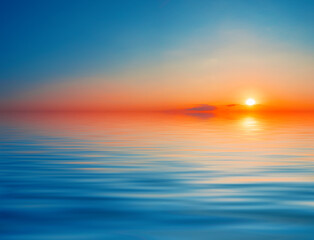 Wall Mural - dramatic orange with blue sky over the water