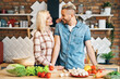 © GVS - Smiling young couple cooking together vegetarian meal in the kitchen at home