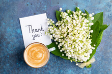 Notes Thank You And Coffee Mug With Bouquet Of Flowers Lily Of The Valley On Blue Background. Thankfulness, Coffee Cup, Customer Service, Thanks Card Concept, Top View, Flat Lay