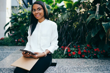 Positive female using tablet in street