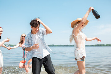 Wall Mural - Drinking, clinking, cheers. Seasonal feast at beach resort. Group of friends celebrating, resting, having fun in sunny summer day. Look happy and cheerful. Festive time, wellness, holiday, party.