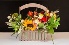 Flower Arrangement With A Sunflower In A Basket On A Black Background. Stylish Flowers For Sale. Artistic Style. Rustic Style. Selective Focus.