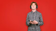 © korolkoff - Teenager with red hair in a screeched shirt on a colored background.