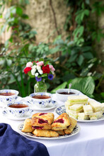 Afternoon Tea In The Garden With Scones, Strawberry Jam, Finger Sandwiches With Cucumber And Egg Salad.