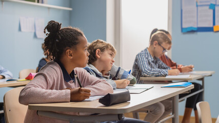 Wall Mural - Elementary Classroom of Diverse Bright Children Listening Attentively to their Teacher Giving Lesson. Brilliant Young Kids in School Learning to Be Great Scientists, Doctors, Programmers, Astronauts