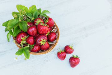 Wall Mural - Fresh strawberries in a basket on rustic wooden background top view. Healthy food on white wooden table mockup. Delicious, sweet, juicy and ripe berry bacgroung with copy space