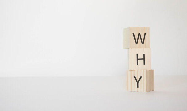 The question WHY is written on wooden cubes on a white background