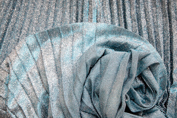 Metal glitter silver cloth background, close up. Trendy Metallic grey fabric texture. Gray sequins, sparkling sequined textile.Gray decorative background of draped fabric with sparkles