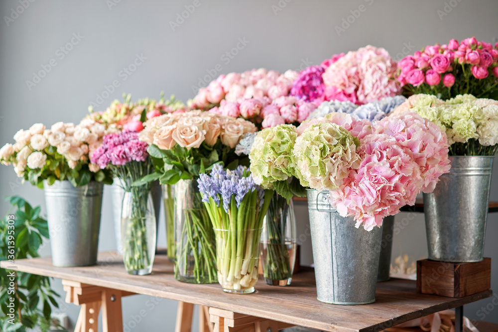 Many different colors on the stand or wooden table in the flower shop. Showcase. Background of mix of flowers. Beautiful flowers for catalog or online store. Floral shop and delivery concept. Top view - obrazy, fototapety, plakaty 