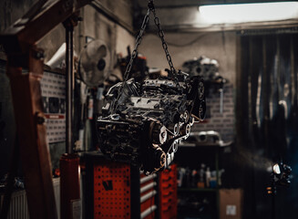 Closeup view of a suspended boxer engine in a dark garage or workshop