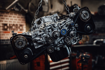 Closeup view of a suspended boxer engine in a dark garage or workshop