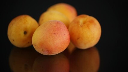 Poster - small handful of ripe apricots on black background