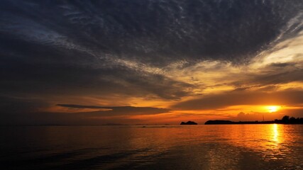 Wall Mural - Sunset time above the ocean, reflective water surface in slow motion during the golden hour