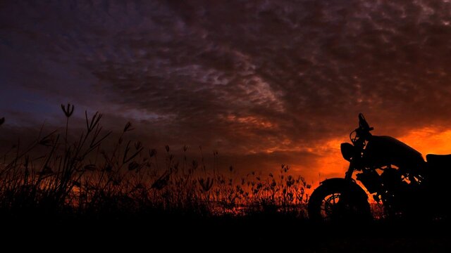 Fototapete - Motorcycle silhouette at sunset time