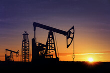 Silhouettes Of Crude Oil Pumps At Sunset