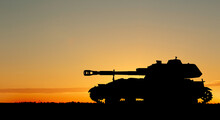 Silhouette Of Army Tank At Sunset Outdoors. Military Machinery