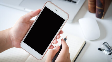 Cropped shot view of man hands holding smart phone with blank copy space screen for your text message or information content, female reading text message on cell telephone during in urban setting. 