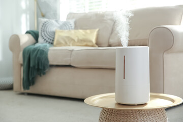 Poster - Modern air humidifier on table in living room. Space for text