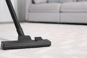 Poster - Hoovering floor with modern vacuum cleaner, closeup. Space for text