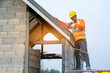 © visoot - Roofer working on roof structure of building on construction site,Worker installing metal roof on roof of new house.