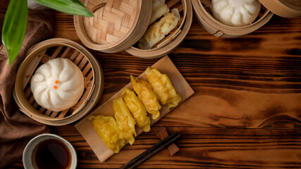 Wall Mural - Top view of steamed dumplings serving on bamboo seamer with hot tea on wooden table