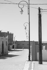 Wall Mural - Grayscale shot of a Moroccan street lined with wrought iron streetlights