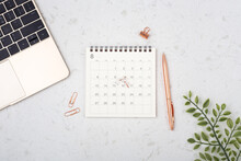 Calendar With Rose Gold Pen And Laptop On White Quartz Table