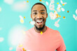 © Carlos David - Portrait of a cheerful black man laughing looking at camera with confetti falling around