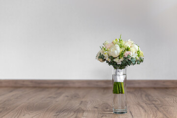 Wall Mural - Wedding bouquet in a glass vase on the stairs near the wall.