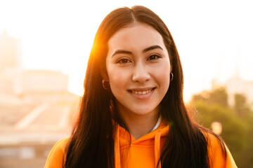 Sticker - Photo of asian woman smiling and looking at camera while walking