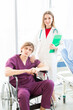 © Masato - Patient in a wheelchair and Female beautiful wearing a doctor uniform standing on the side.
