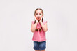 © Nastya - Pleasant cute upbeat little girl holding her hands near face and surprising