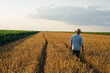 © cherryandbees - farmer walking on through wheat field
