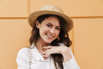 Poster - Portrait of cheerful woman in straw hat laughing and looking at camera