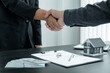 © Orathai - A real estate agent and clients shake hands after completing the home insurance contract negotiation and signing a formal contract. Rental and home insurance concepts