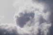 background of grey atmospheric clouds with a dark grey circle covered by lighter clouds