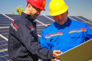 Green energy, power plant and two electricians with laptop