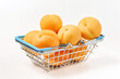 Supermarket mini basket with ripe apricots isolated on white background.