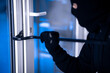 © Prostock-studio - Robber in black balaclava cracking door with the crowbar