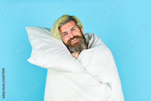 Just relaxing. Carefree guy enjoying a new day. good morning routine. Caucasian bearded guy wrapped in white blanket. relax in a hotel room in blanket. bearded mature man lying at home