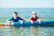 © spass - Two happy siblings teen children in neoprene suits having fun  with sup board in Baltic sea