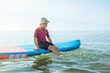 © spass - Portrait of cute teen child girl playing on sup board in water in Baltic sea