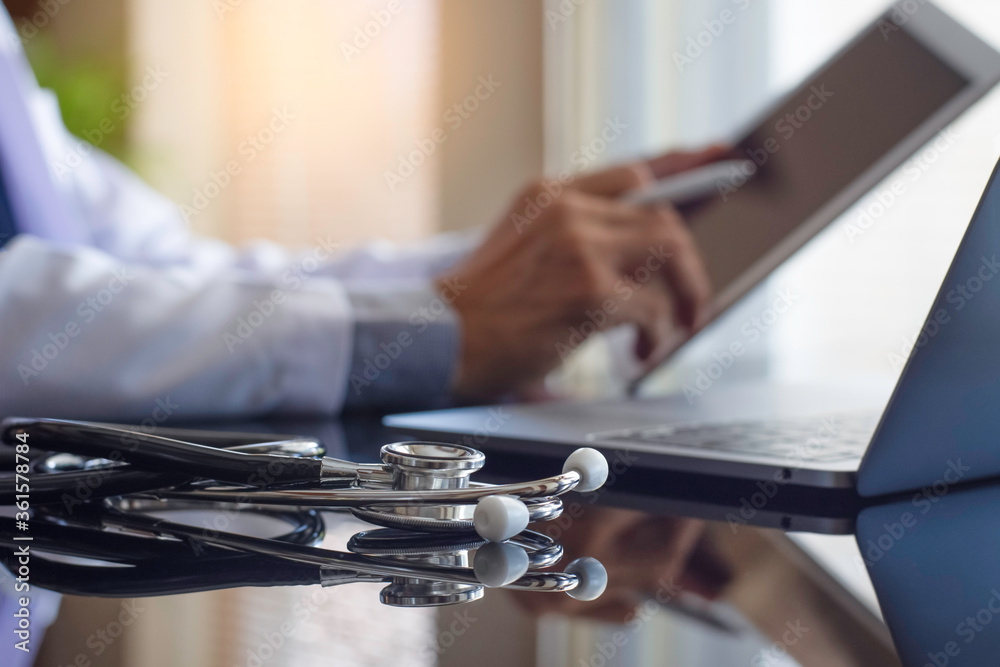 Male doctor using tablet, work on laptop computer with medical ...