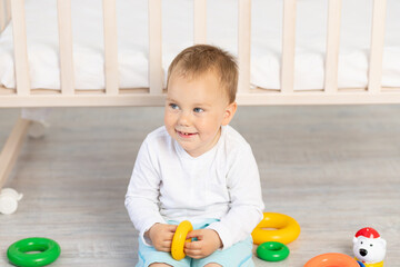 portrait a little boy 2 years old playing near the crib, early development