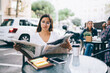 © GalakticDreamer - Serious woman reading newspaper outside cafe