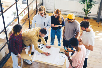 Top view of professional architects collaborating on creating new planning of office building during brainstorming,creative students working on improving design project during productive cooperating