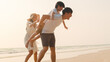 © tirachard - Asian young happy family enjoy vacation on beach in the evening. Dad, mom and kid relax playing together near sea when sunset while travel holiday. Lifestyle travel holiday vacation summer concept.